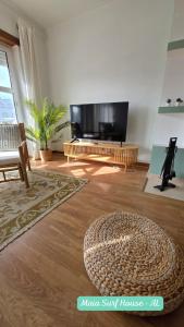 a living room with a large flat screen tv at Maia Surf House - Baleal in Ferrel