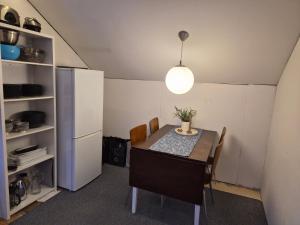 a dining room with a table and a refrigerator at Arctic Sea house in Svensby