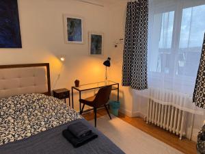 a bedroom with a bed and a desk and a window at Villa Auguste chambres d'hôtes in Quimper +39 photos