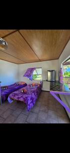 a room with two beds and a tv in it at Pension Tipapa in Tikehau