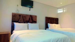 a bedroom with two beds and a tv on the wall at Ijumba Signature Hotel in Bellville +28 photos