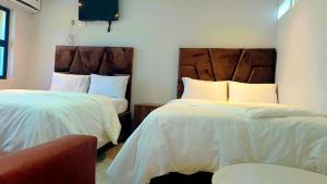 a hotel room with two beds and a chair at Ijumba Signature Hotel in Bellville