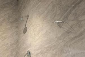 a shower in a bathroom with a beige at Ijumba Signature Hotel in Bellville