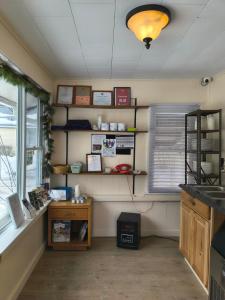 a room with a kitchen with shelves and a window at The Ashley in Saranac Lake
