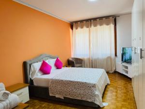 a bedroom with a bed with pink pillows and a tv at First Dream Mestre in Mestre +14 photos