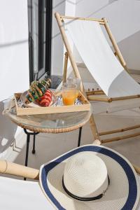 a tray with a straw hat and a glass of orange juice at Xenia Residence in Faliraki