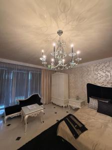 a bedroom with a bed and a chandelier at Lily Rose villa in Karlovy Vary