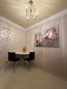 a dining room with a table and chairs and a painting at Lily Rose villa in Karlovy Vary