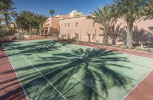 a shadow of a palm tree on a tennis court at Ksar El Jerid in Tozeur