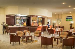 a hotel lobby with a bar and chairs and a woman at Ksar El Jerid in Tozeur
