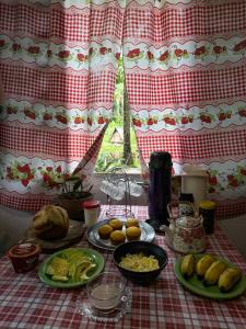 a table with plates of food on a red and white table cloth at Chalé Moon - Vale do ribeira in Juquiá