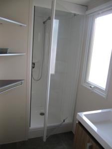 a white bathroom with a shower and a sink at Camping du Mouchet in La Chapelle-Viviers +41 photos
