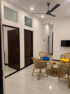 a living room with chairs and a table and a ceiling fan at Shelo Transit Hotel in Katunayaka