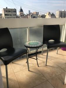 two chairs and a table on a balcony at Studios Montevideo in Buenos Aires