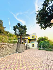 a house with a tree in front of it at Yatri Lakeview Villa in Pune +2 photos