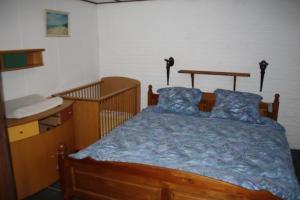 a bedroom with a wooden bed with blue sheets at Landhuis "Op de Heugte" in Norg