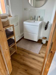a bathroom with a sink and a mirror at stylisches Ferienhäuschen in Güstrow +8 photos