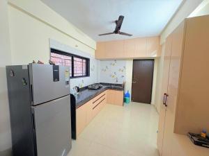 a kitchen with a refrigerator and a ceiling fan at Yatri Lakeview Villa in Pune