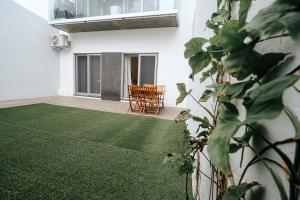 a room with a green carpeted floor and a chair at Peace In Azores in Pico da Pedra