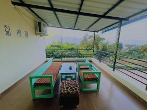 a balcony with tables and chairs and a view of trees at Yatri Lakeview Villa in Pune