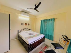 a bedroom with a bed and a ceiling fan at Yatri Lakeview Villa in Pune