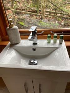 a bathroom sink with two candles and a window at Bijou Cabin in Ludlow