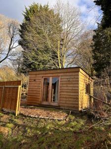 a small cabin with a window in a field at Bijou Cabin in Ludlow
