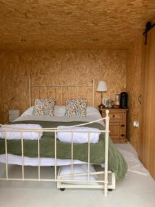 a bedroom with a bed and a wooden wall at Bijou Cabin in Ludlow