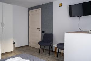 a room with two chairs and a tv on a wall at Casa Puiu in Câmpulung Moldovenesc