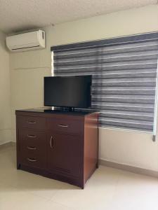 a television on a dresser in a room with a window at Hacienda Rosarito in Rosarito Beach +49 photos