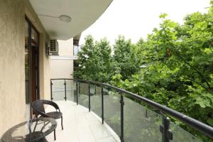 a balcony with two chairs and a table at Holidays inkutaisi in Tsqnetʼi