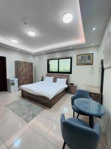 a bedroom with a bed and a table and a chair at Quba Suites نزل قباء in Medina
