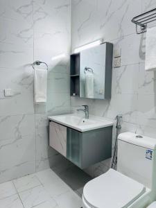a white bathroom with a sink and a toilet at Quba Suites نزل قباء in Medina +58 photos