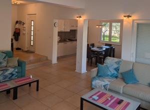 a living room with two couches and a kitchen at Dee's House and Pool in Labin