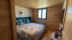 a bedroom with a bed in a log cabin at Le Chalet in Selonnet