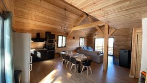 a kitchen and a living room with a table and chairs at Le Chalet in Selonnet