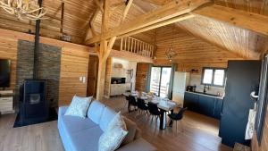 a living room with a couch and a table with chairs at Le Chalet in Selonnet