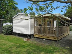 a tiny house with a porch and a deck at Camping du Mouchet in La Chapelle-Viviers