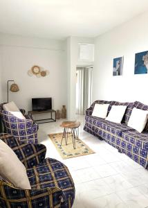 a living room with two couches and a tv at Ftero Traditional Retreat in Manganítis