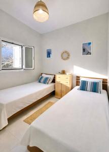 a bedroom with two beds and a window at Ftero Traditional Retreat in Manganítis