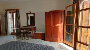 a bedroom with a desk and a table and a mirror at Vaporia in Ermoupoli +23 photos