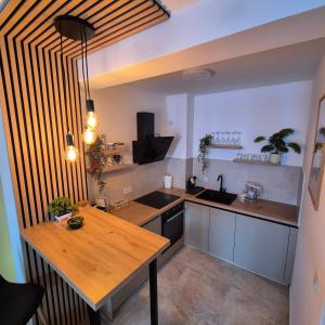 a kitchen with a wooden counter top in a room at Aura Apartment FREE PARKING in Brčko