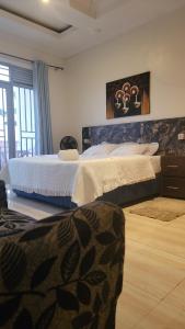 a bedroom with a large bed and a large window at Puma Aparthotel - Nyarutarama in Kigali