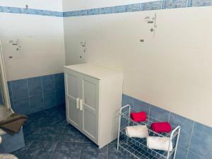 a bathroom with two red chairs and a cabinet at Chiasso Swiss Apartment by RentuGoo Travel in Chiasso +16 photos