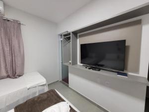a bedroom with a flat screen tv on a wall at Pousada Novo Millenium in Araripina