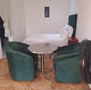 a room with a table and two chairs and a bed at Aquamarine Guesthouse in Morula Sun