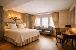 a bedroom with a bed and a desk and chairs at Relais Bourgondisch Cruyce, A Luxe Worldwide Hotel in Bruges +41 photos