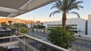 a view from the balcony of a building with a palm tree at Royal Park A&7 Deluxe, swim pool - by G&P suites in Eilat