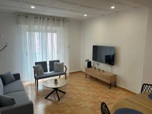 a living room with a couch and a flat screen tv at Entrevías in Albacete