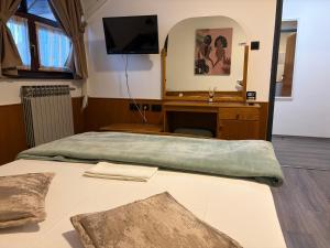 a bedroom with a bed with a desk and a mirror at Guest house Royal in Čakovec